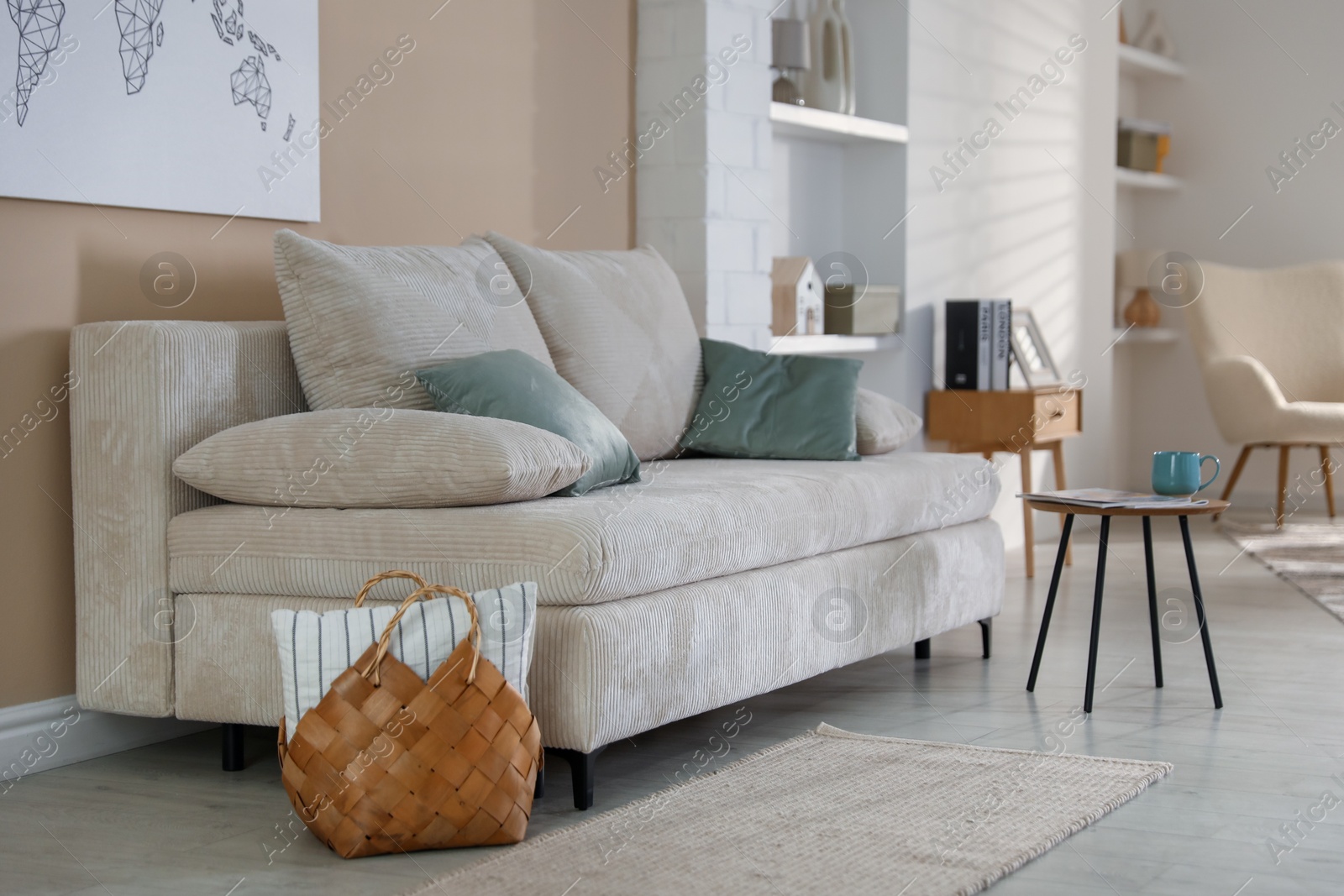 Photo of Comfortable sofa with pillows and side table in living room