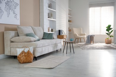 Photo of Comfortable sofa with pillows and side table in living room