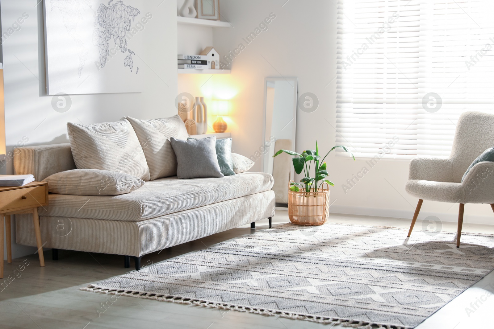 Photo of Comfortable sofa with pillows, armchair and houseplant in living room