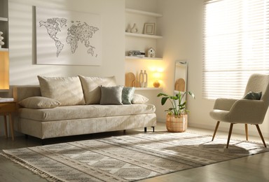 Photo of Comfortable sofa with pillows, armchair and houseplant in living room