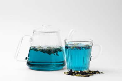 Photo of Fresh butterfly pea flower tea and dry petals on white table, closeup