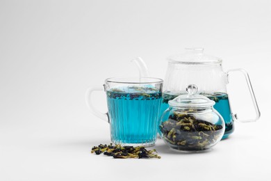 Photo of Fresh butterfly pea flower tea and dry petals on white table. Space for text