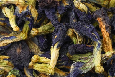 Photo of Butterfly pea flower tea. Dry Clitoria ternatea petals as background, top view