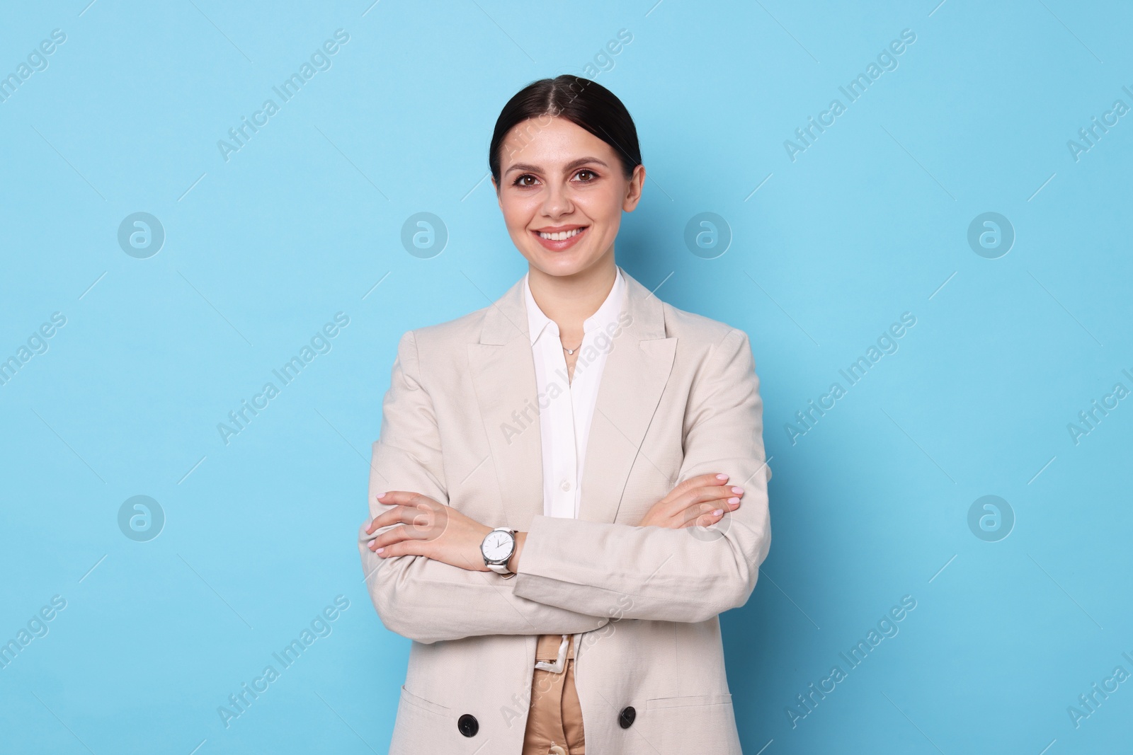 Photo of Portrait of banker with crossed arms on light blue background