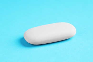 Photo of One eraser on light blue background, closeup