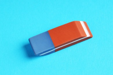 Photo of One eraser on light blue background, above view