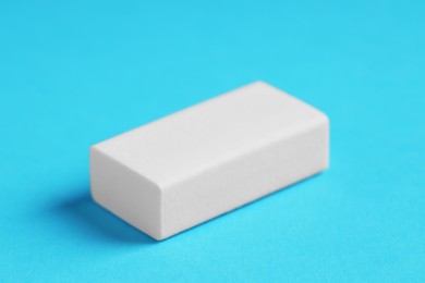 Photo of One eraser on light blue background, closeup