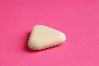 Photo of One eraser on pink background, closeup view