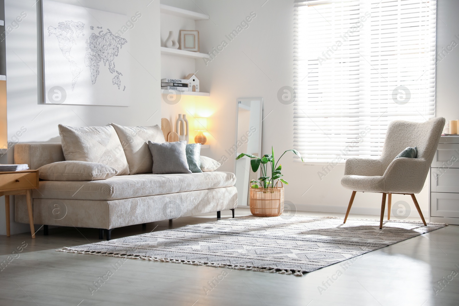 Photo of Comfortable sofa with pillows, armchair and houseplant in living room