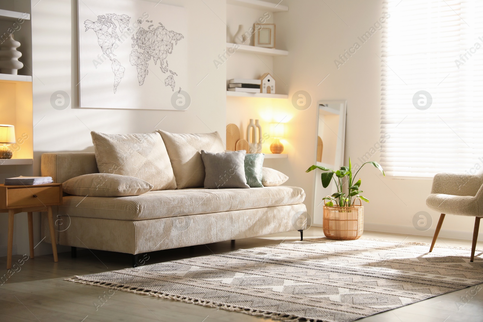 Photo of Comfortable sofa with pillows and houseplant in living room