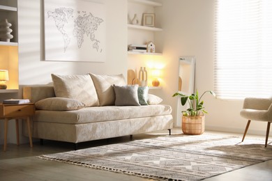 Photo of Comfortable sofa with pillows and houseplant in living room