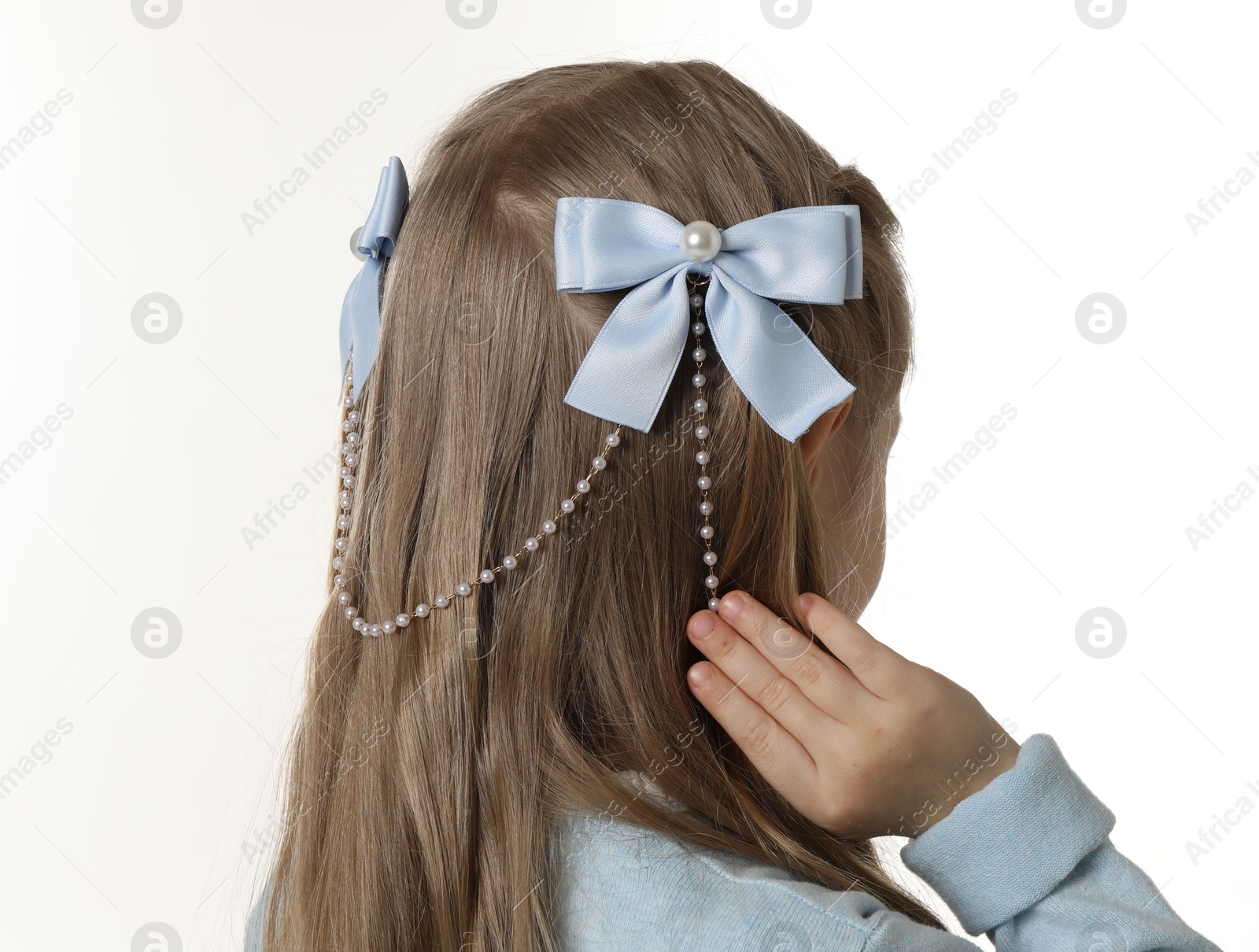 Photo of Cute little girl with beautiful hair accessory on white background, back view