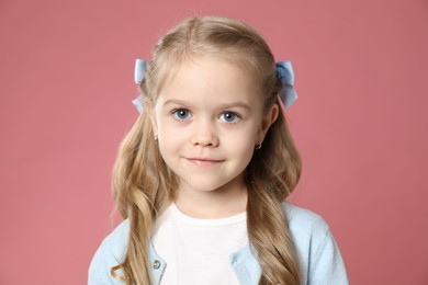 Photo of Cute little girl with beautiful hair accessory on coral background