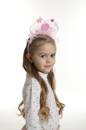 Photo of Cute little girl with beautiful headband on white background