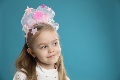 Photo of Cute little girl with beautiful headband on blue background. Space for text