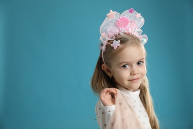 Photo of Cute little girl with beautiful headband on blue background. Space for text