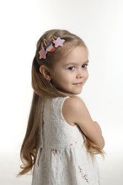 Photo of Cute little girl with beautiful hair clips on white background