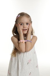 Photo of Cute little girl with beautiful hair clips on white background