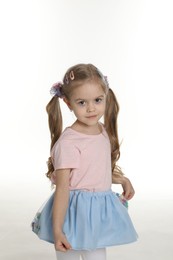 Photo of Cute little girl wearing beautiful hair accessories on white background