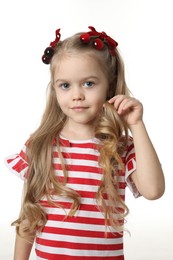 Photo of Cute little girl wearing beautiful bows with cherries on white background