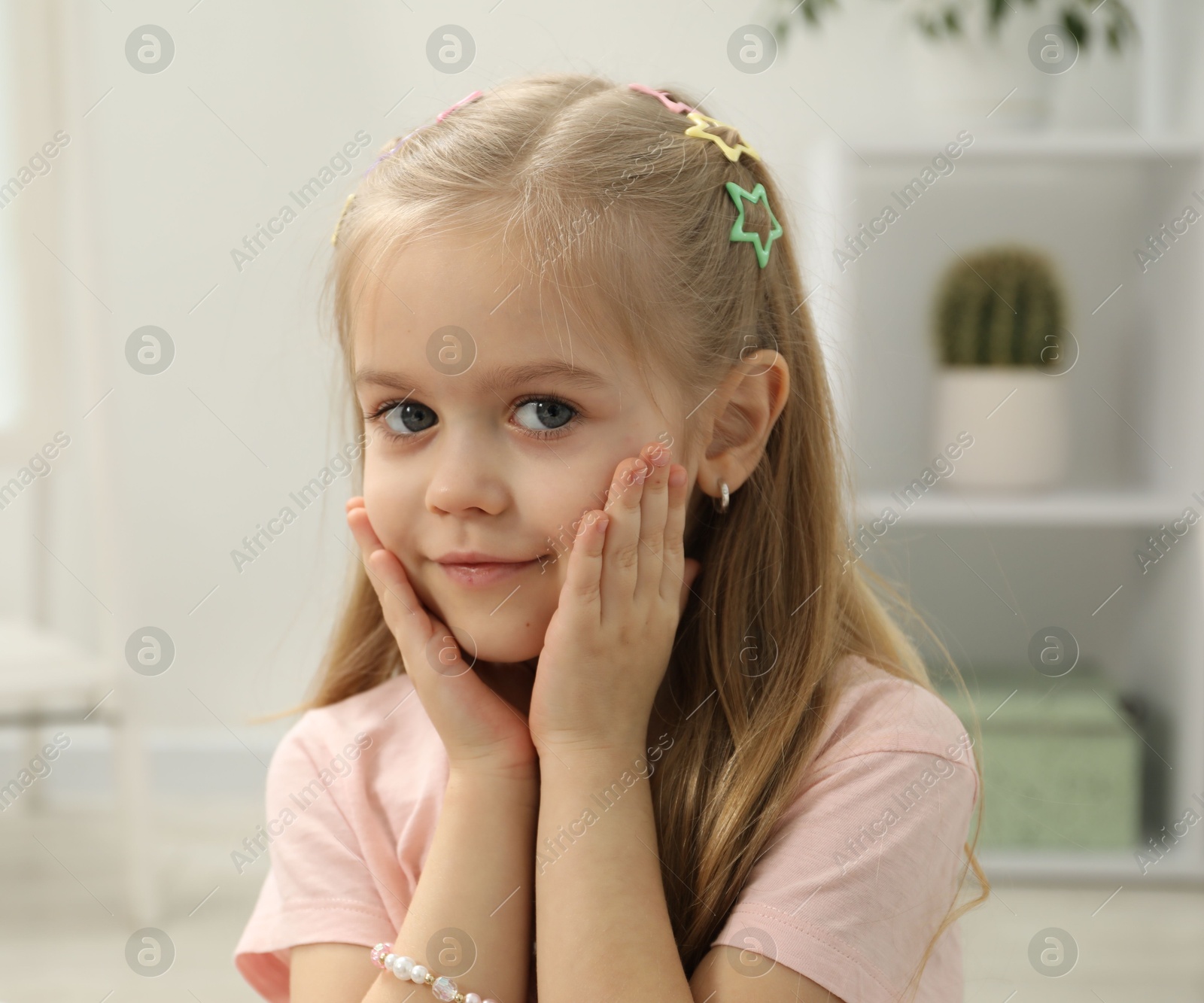 Photo of Little girl with many cute hair accessories at home