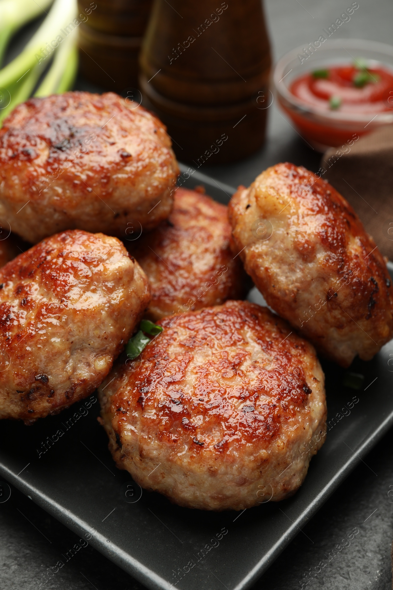 Photo of Delicious roasted patties on black table, closeup