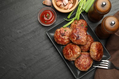 Photo of Delicious patties served on black table, flat lay. Space for text