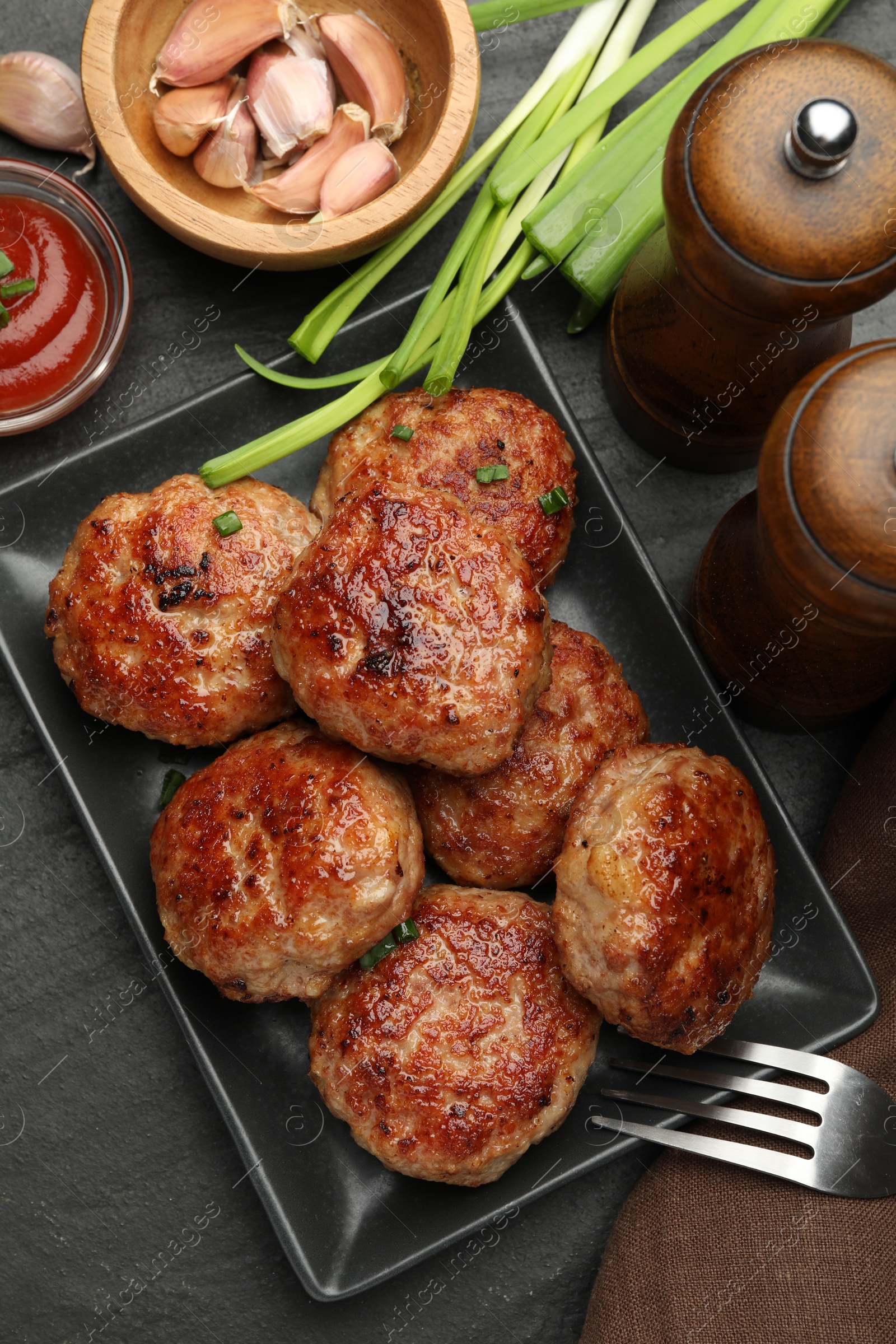 Photo of Delicious patties served on black table, flat lay