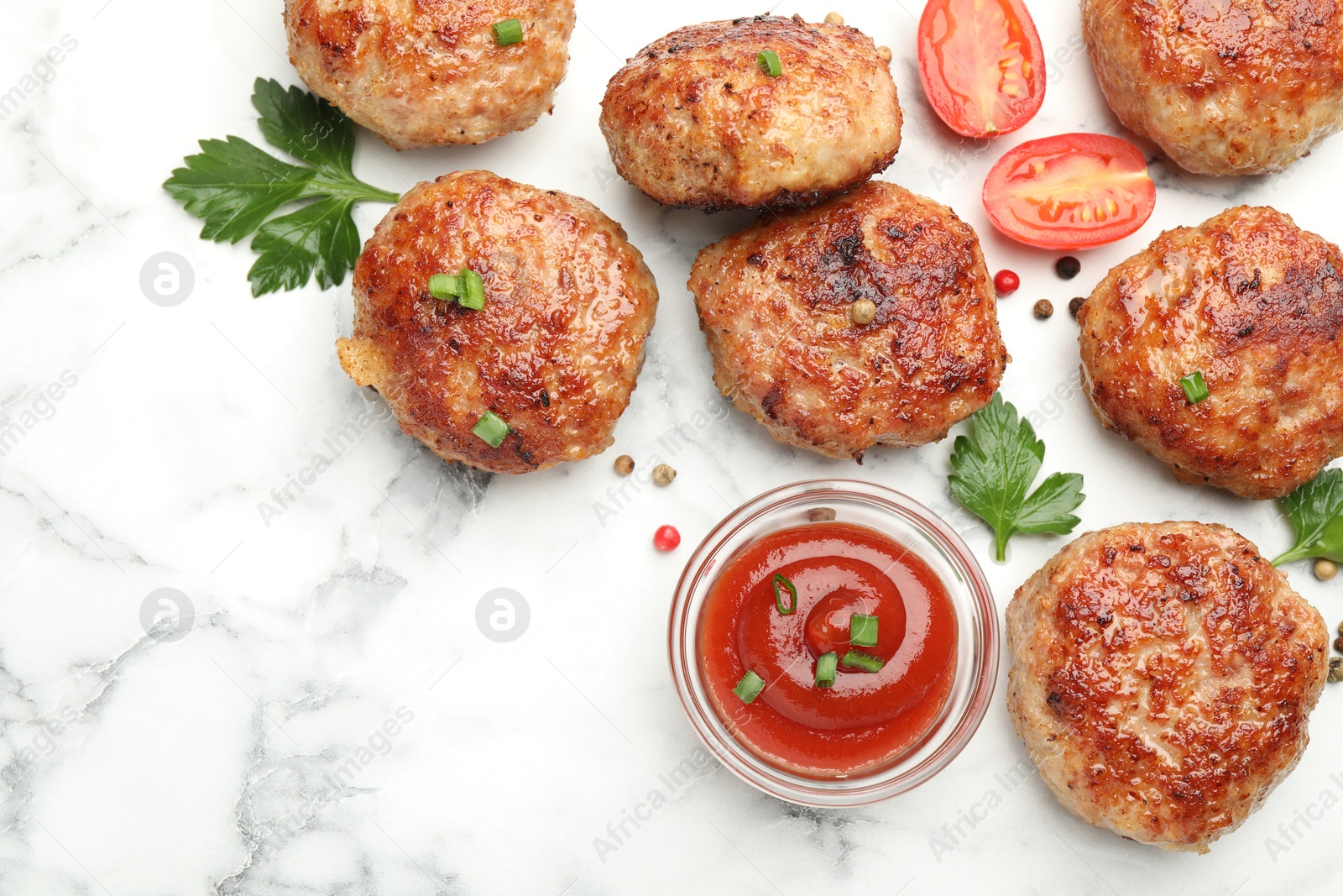 Photo of Delicious patties with sauce, cherry tomatoes, peppercorns and parsley on white marble table, flat lay. Space for text