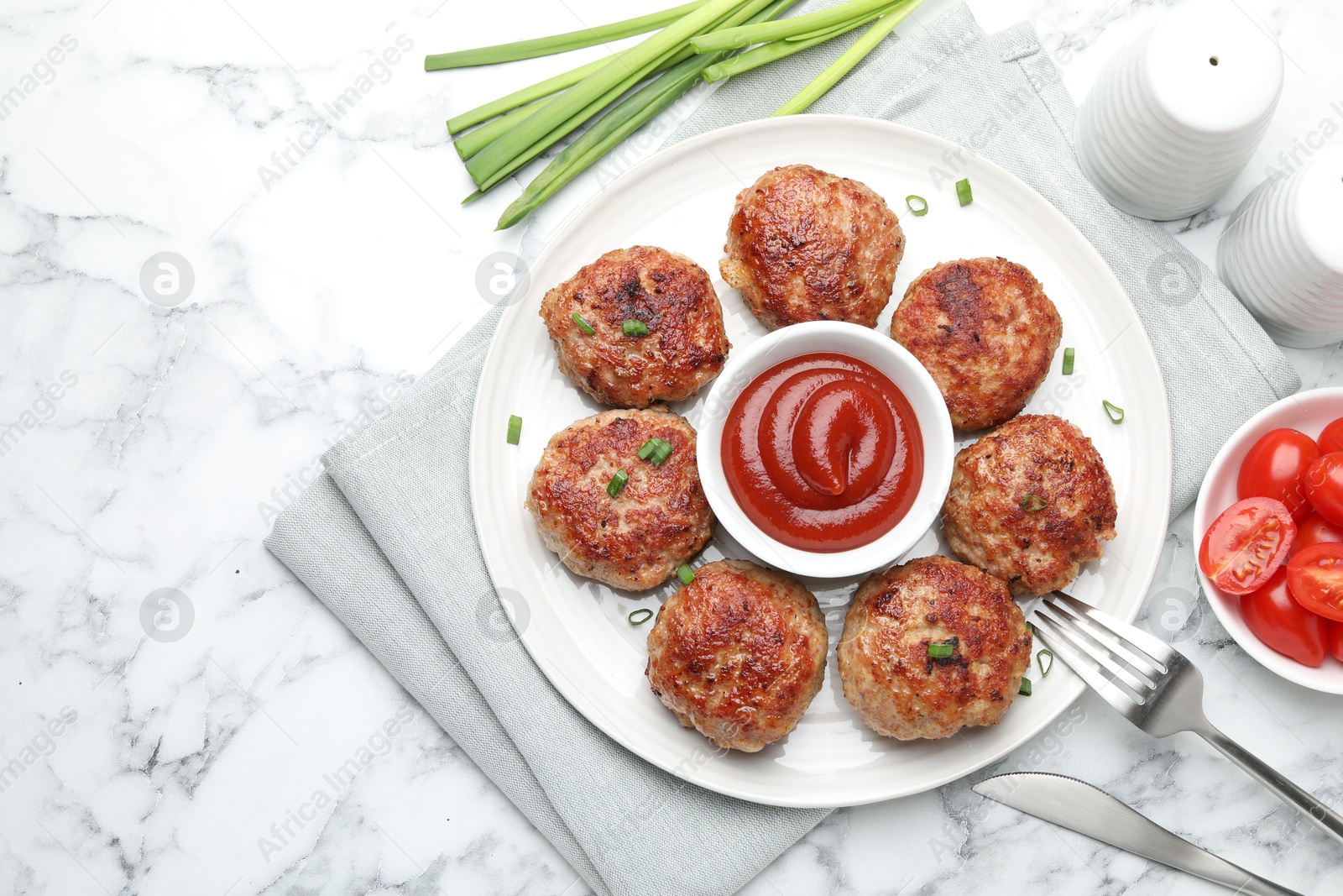 Photo of Delicious patties served on white marble table, flat lay