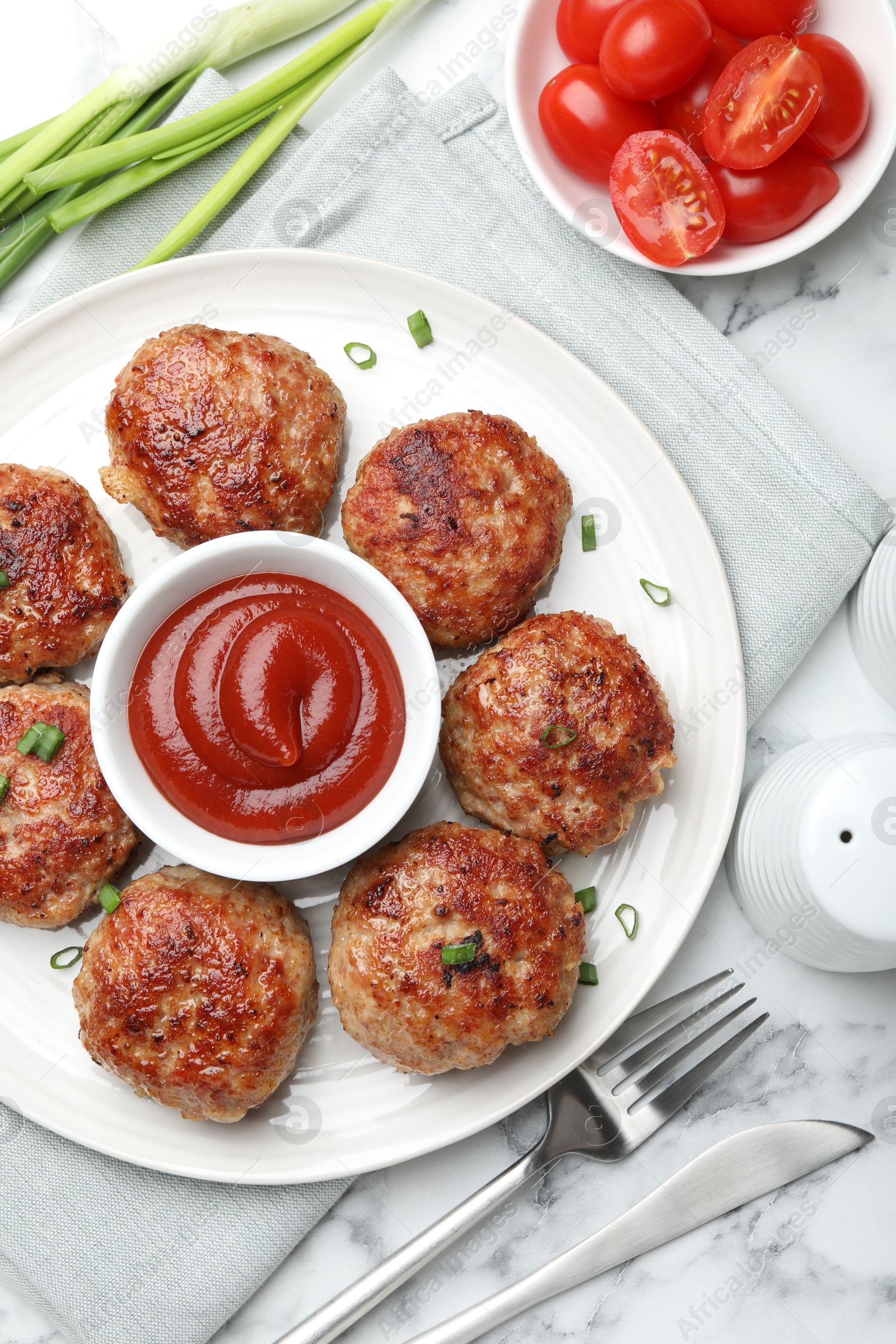 Photo of Delicious patties served on white marble table, flat lay