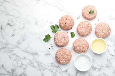 Photo of Many uncooked patties and spices on white marble table, flat lay. Space for text