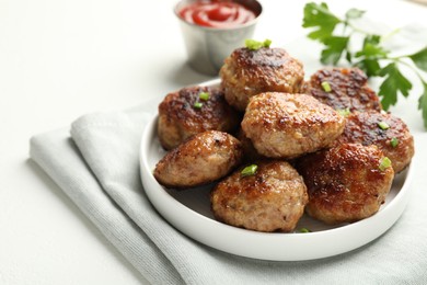 Photo of Delicious patties with green onions, parsley and ketchup on white table, closeup