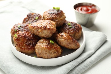 Photo of Delicious patties with green onions and ketchup on white table, closeup