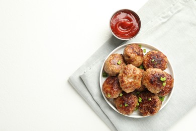 Photo of Delicious patties with green onions and ketchup on white table, top view. Space for text