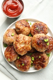 Photo of Delicious patties with green onions and ketchup on white table, top view