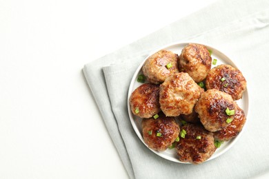 Photo of Delicious patties with green onions on white table, top view. Space for text