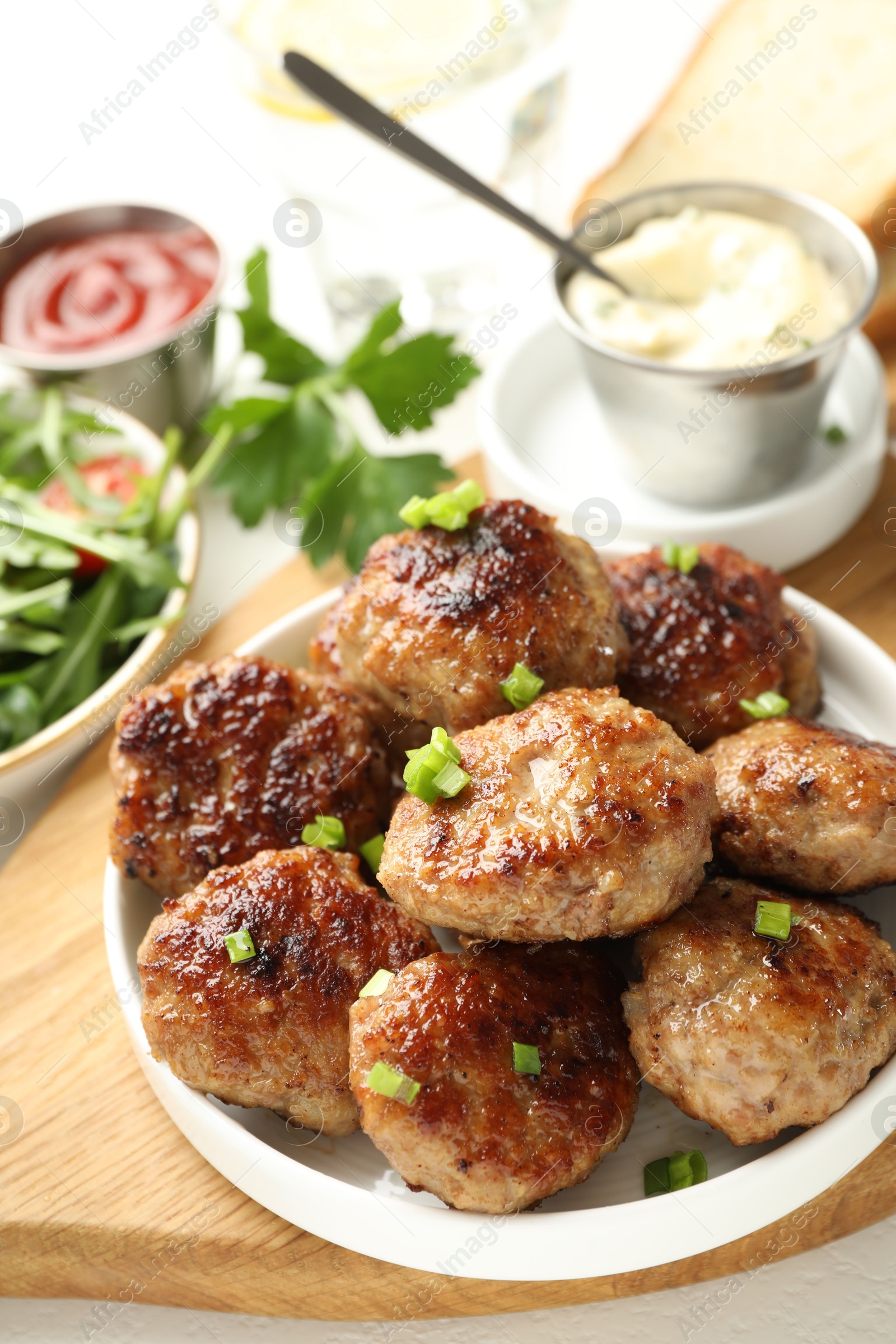 Photo of Delicious patties with green onions served on table, closeup