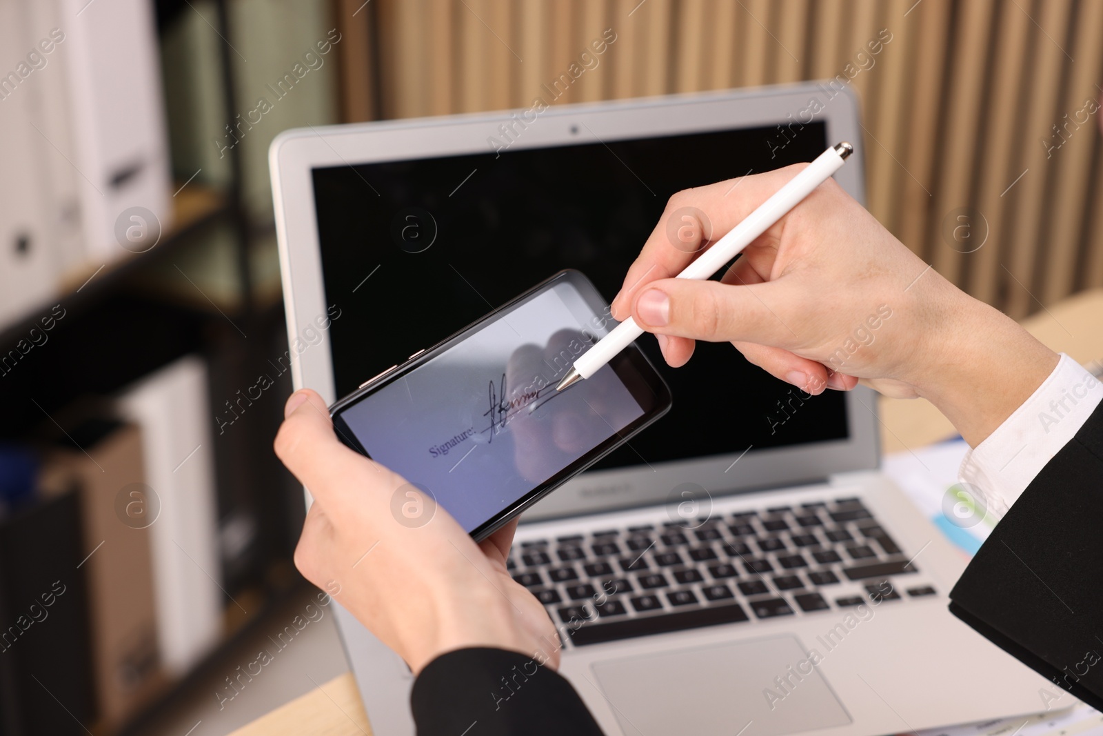 Photo of Electronic signature. Man using stylus and smartphone at table indoors, closeup