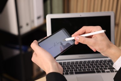 Photo of Electronic signature. Man using stylus and smartphone at table indoors, closeup