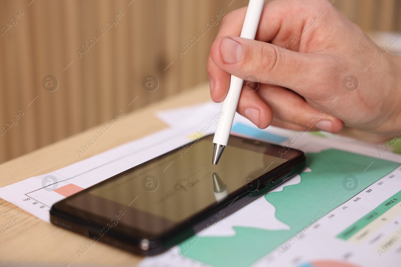 Photo of Electronic signature. Man using stylus and smartphone at table, closeup