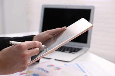 Photo of Electronic signature. Man using stylus and tablet at table, closeup