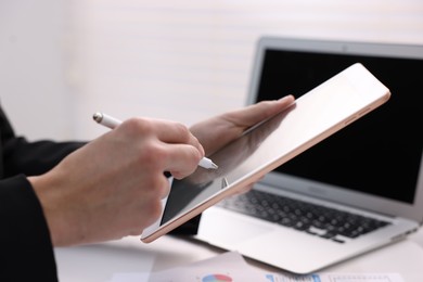 Photo of Electronic signature. Man using stylus and tablet at table, closeup