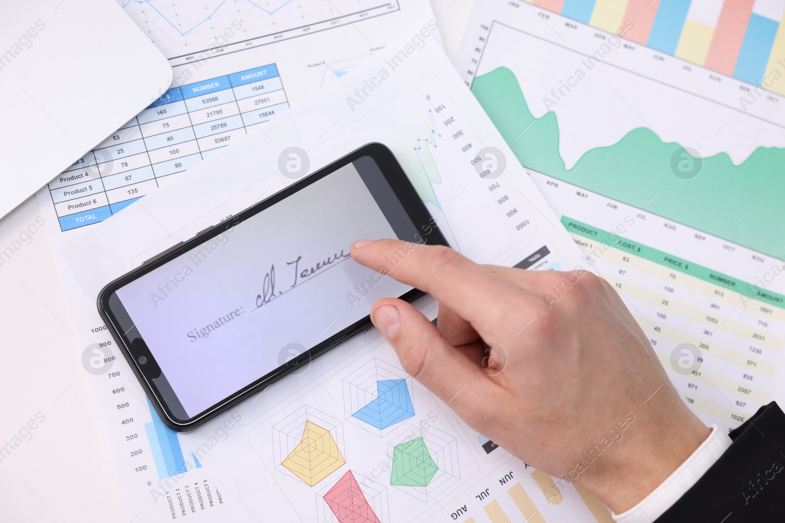 Photo of Electronic signature. Man using smartphone at table, top view