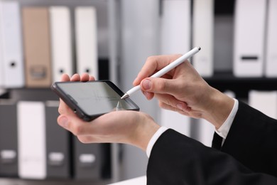 Photo of Electronic signature. Man using stylus and smartphone indoors, closeup