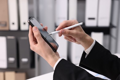 Photo of Electronic signature. Man using stylus and smartphone indoors, closeup