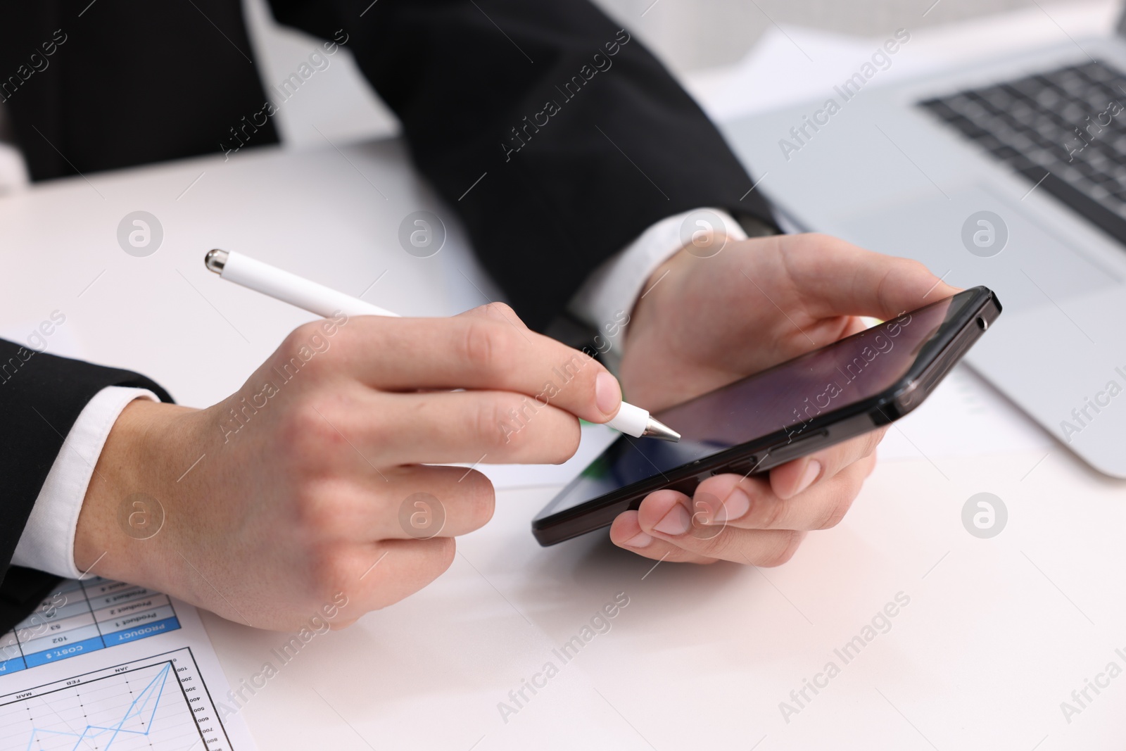 Photo of Electronic signature. Man using stylus and smartphone at white table, closeup