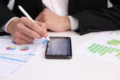 Photo of Electronic signature. Man using stylus and smartphone at white table, closeup