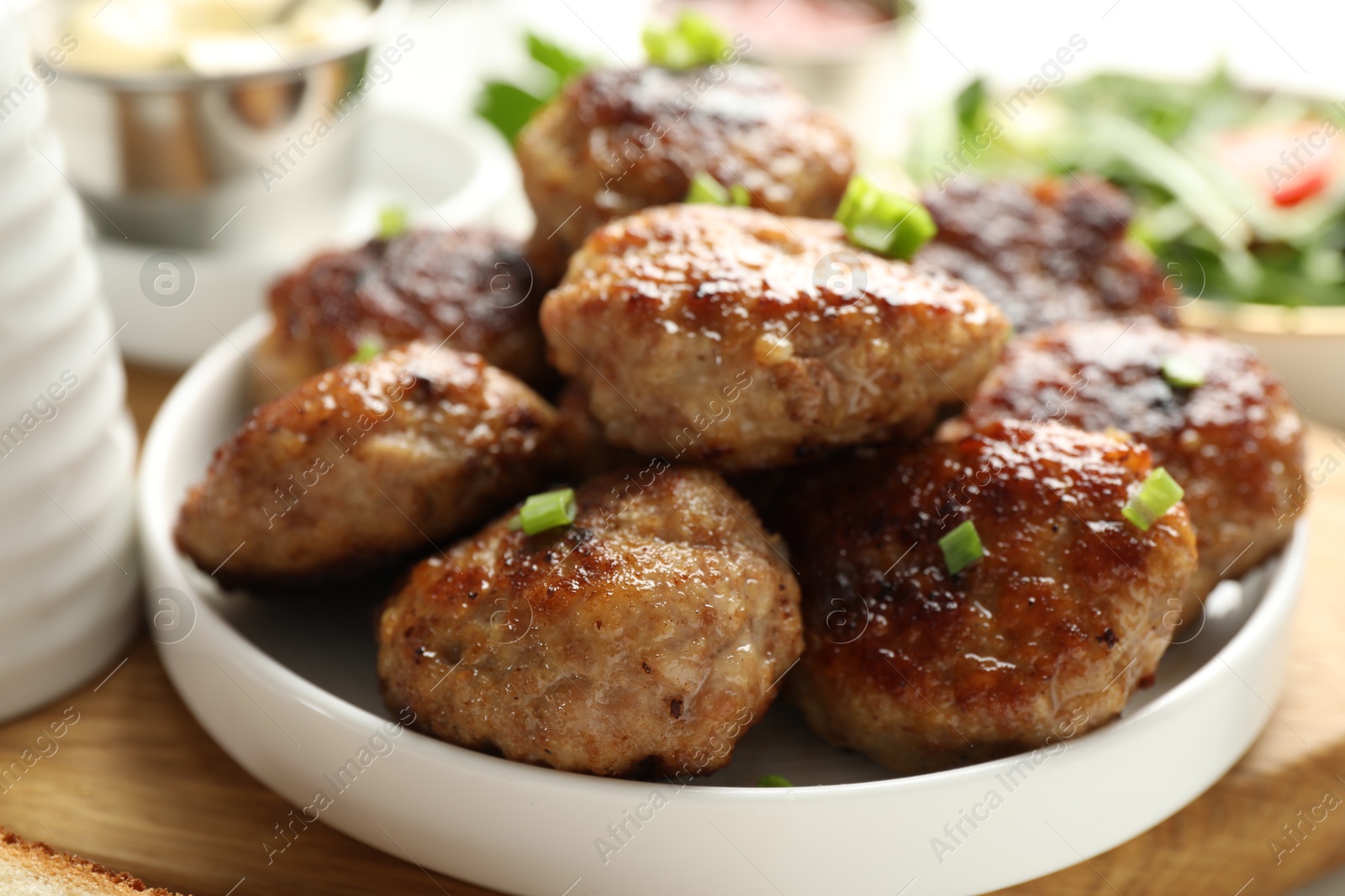 Photo of Delicious patties with green onions on table, closeup