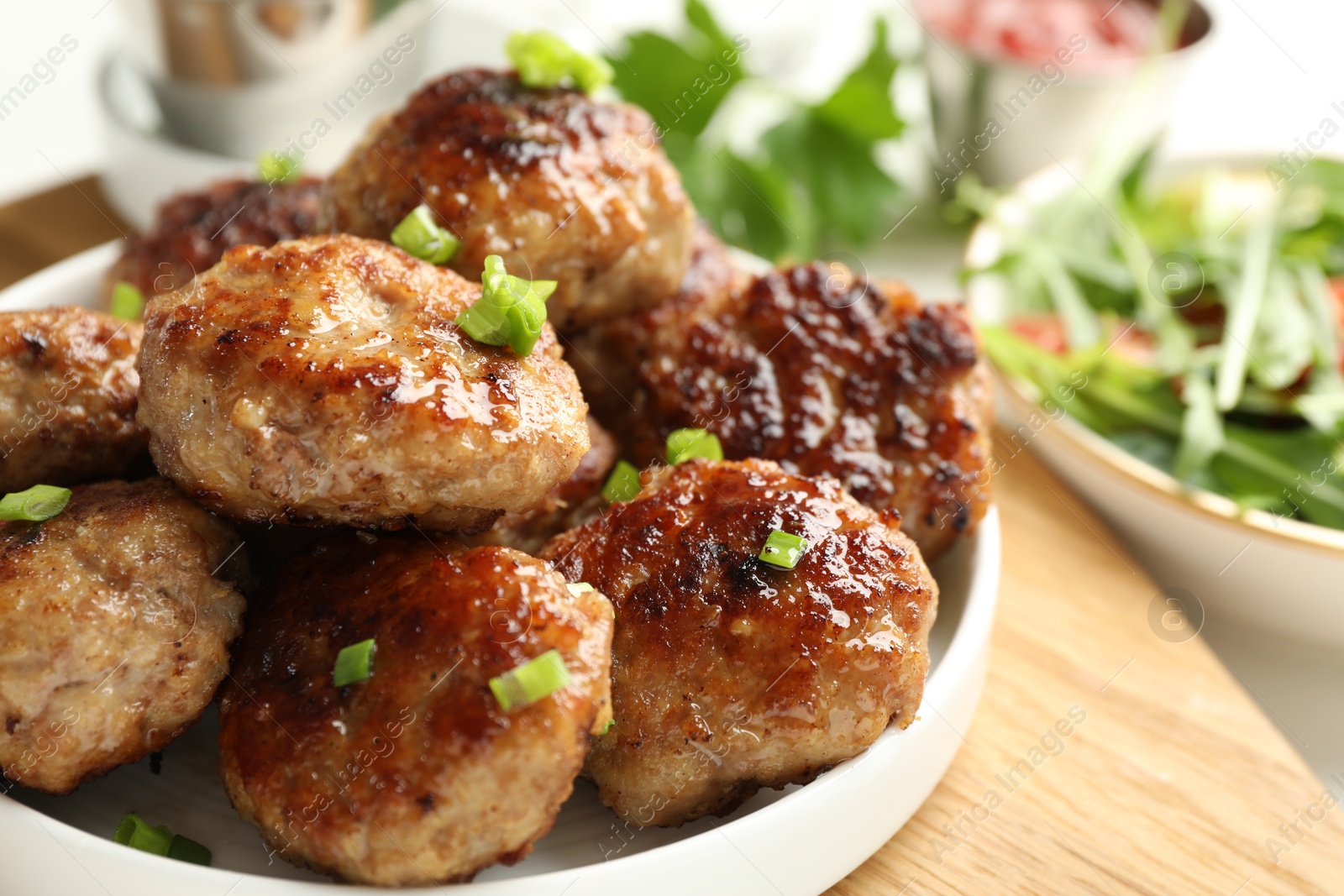 Photo of Delicious patties with green onions on table, closeup